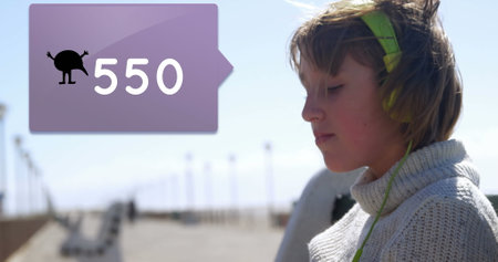 Image of numbers changing with icon on speech bubble over woman with headphones and smartphone. global connections, data processing and digital interface concept digitally generated imageの写真素材