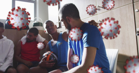 Image of covid 19 cells over football players in changing rooms. sports and competition during coronavirus pandemic concept digitally generated image.の写真素材