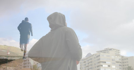 Composite of man jogging in countryside and man jogging in city. health, fitness and wellbeing concept digitally generated image.の写真素材