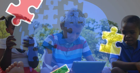 Image of colourful puzzle pieces and human head over children using tablets. autism, learning difficulties, support and awareness concept digitally generated image.の写真素材