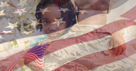 Image of flag of america blowing over african american daughter with flag hugging soldier father. patriotism, independence and celebration concept digitally generated image.の写真素材