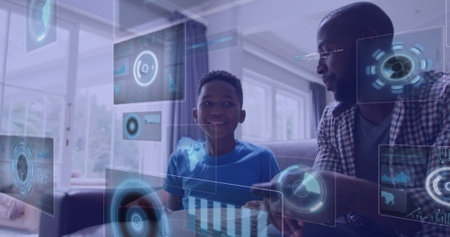 Image of digital screens over smiling african american father with son watching tv. global connections and digital interface concept digitally generated image.の写真素材