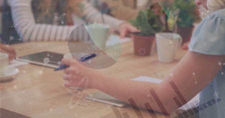 Image of financial data processing over businesswoman writing in office. global business, data processing and digital interface concept digitally generated image.の写真素材