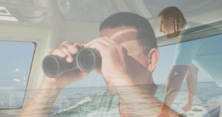 Image of caucasian man using binoculars over caucasian man sailing. hobby and lifestyle concept...