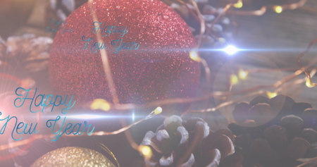 Image of happy new year text over christmas decorations. new year, tradition and celebration concept...