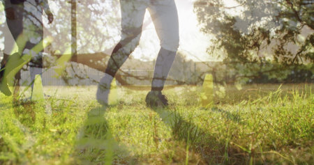 Image of grass over legs of men playing football. global sports, healthy and active lifestyle concept digitally generated image.の写真素材