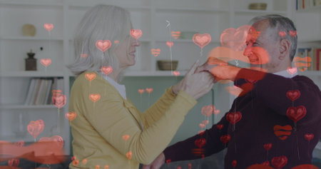 Image of heart icons over senior caucasian couple dancing. spending time at home concept digitally generated image.の写真素材