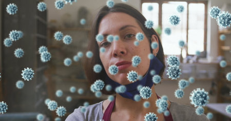 Composite image of covid-19 cells floating against female caucasian potter smiling. pottery and...