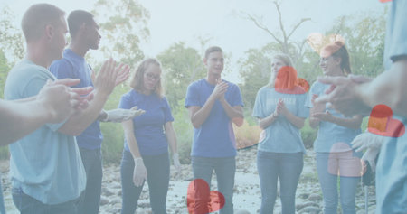 Image of hearts over diverse people cleaning in forest. earth day and celebration, concept digitally...