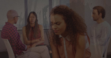 Textured scratched overlay against stressed african american woman holding her head at office. business and office conceptの写真素材