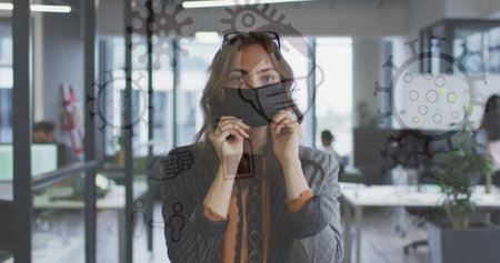 Image of medical icons over caucasian businesswoman wearing face mask. global medicine, medical services during covid 19 pandemic concept digitally generated image.の写真素材