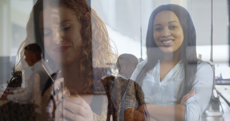 Image of happy caucasian woman having call over biracial businesswoman in office. global business,...