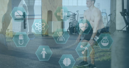 Image of medical and health icons over caucasian man exercising in gym. active healthy lifestyle and sports concept digitally generated image.の写真素材