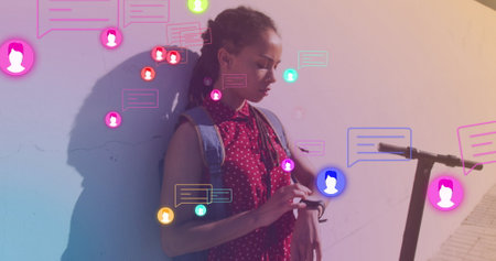 Image of media icons over biracial woman with scooter using smartwatch. health and fitness concept digitally generated image.の写真素材