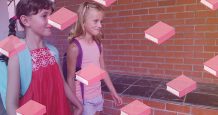 Image of books over caucasian schoolgirls walking on corridor. education, learning and back to school concept digitally generated image.の写真素材