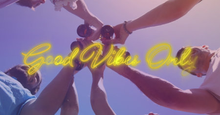 Image of good vibes only over hands of diverse male friends toasting with beer. drinking beer,...