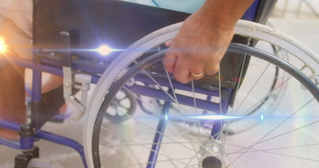 Spot of light against mid section of disabled man walking on wheelchair. handicap and disability...