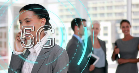 Image of 5g over biracial businesswoman using smartphone in office. business, network, communication and technology concept digitally generated image.の写真素材