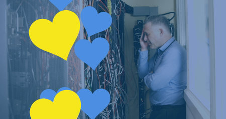 Image of hearts over caucasian businessman in server room. global technology and digital interface...