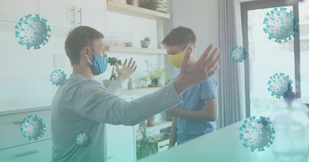 Wearing face masks, father and son keeping distance in modern home kitchen, with coronavirus icons. Family, protection, hygiene, safety, health, domestic, lifestyleの写真素材