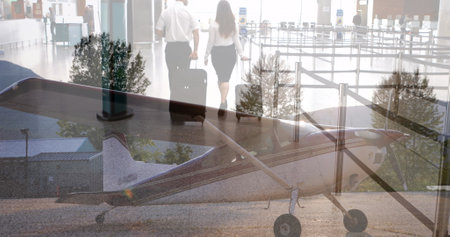 Composite image of plane at airport against businessman and businesswoman walking with trolley bags. Aviation business conceptの写真素材