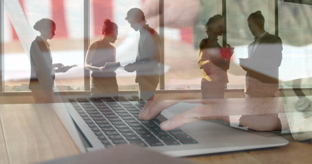 Image of diverse group of business people over person using laptop. Global business, finances, data processing and digital interface concept digitally generated image.の写真素材