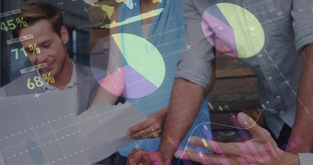 Collaborating professionals reviewing charts and data overlays in office, with laptop smartphone. Business, teamwork, analytics, corporate, innovation, strategy, productivityの写真素材