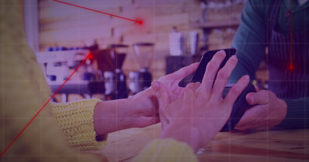 Tapping smartphone against black payment terminal at wooden coffee shop counter, with jars and mugs. Technology, commerce, retail, modern, transaction, hospitality, cozyの写真素材