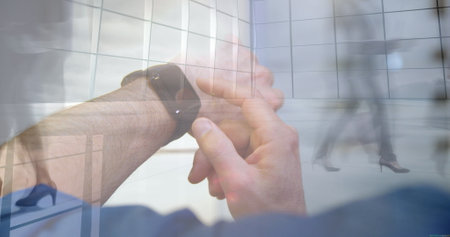 Business man and hands adjusting smartwatch in corporate lobby, with grid glass panels. technology, innovation, modern, professional, sleek, connectivity, corporateの写真素材