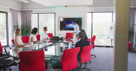Presenting professional pointing at data graph on screen in meeting room, glass table laptops....