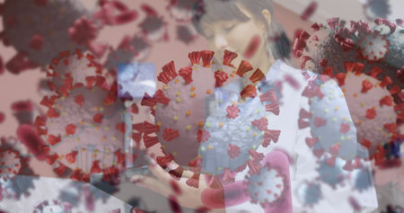 Image of covid cells over male doctor in face mask. Digitally generated image.の写真素材