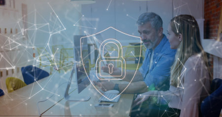 Professionals in business casual reviewing security data at conference table, with network graphics. Cybersecurity, data protection, teamwork, innovation, modernity, collaboration, technologyの写真素材