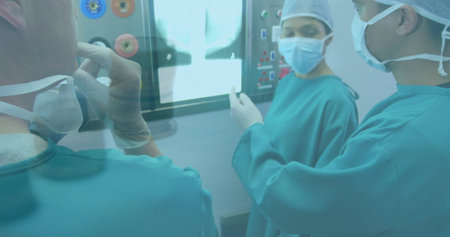 Financial data processing over team of diverse surgeons discussing in operation theatre. Medical healthcare and technology conceptの写真素材