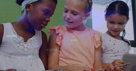 Using tablets three schoolgirls collaborating at classroom desk, with digital grid overlay....