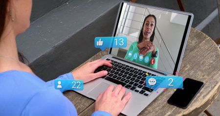 Digital icons with increasing numbers over caucasian girl having a imagecall on laptop at a cafe....