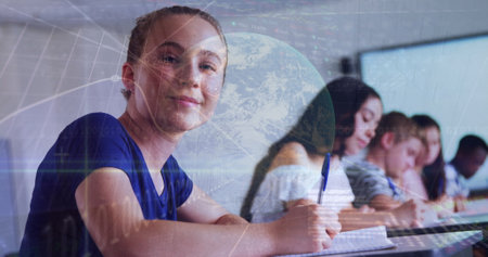 Image of graph and globe over smiling caucasian girl and class of diverse pupils at school. School, education, learning, finance and economy concept digitally generated image.の写真素材