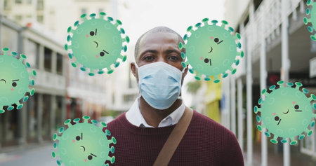 Image of falling covid 19 cells over african american men wearing face mask. Global covid 19 pandemic, science and connections concept digitally generatedの写真素材