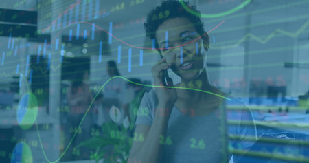 Image of data processing over african american businesswoman using smartphone in office. Global business and digital interface concept digitally generated image.の写真素材