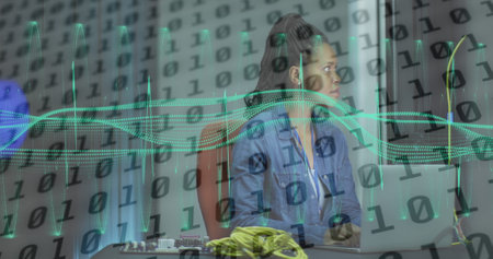 Image of data processing over african american female server room worker using laptop. Cloud computing concept digitally generated image.の写真素材