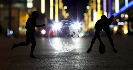 Image of globe and american footballer silhouettes over car on city street at night. Global communication, sport, travel and digital interface concept digitally generated image.の写真素材