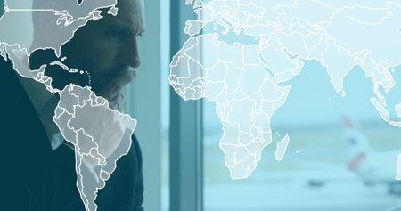 Image of world map over caucasian businessman at airport. Global business and digital interface...