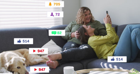Image of social media icons falling over two caucasian women using smartphone. Social media and...