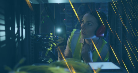 Image of moving lights over caucasian female server room worker. Cloud computing concept digitally...