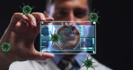 Image of covid 19 cells and data processing on screen over caucasian male doctor. Global covid 19 pandemic, data processing and healthcare services concept digitally generated image.の写真素材