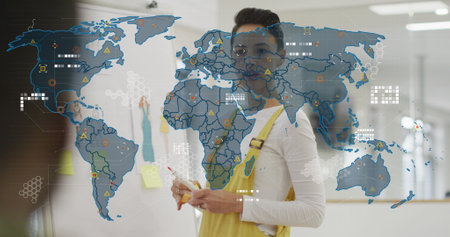 Image of world map over businesswoman in office. Global business and digital interface concept digitally generated image.の写真素材
