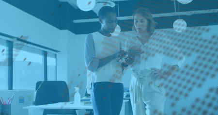 Image of graphs and globe over diverse female coworkers in office. Business, finance, network and technology concept digitally generated image.の写真素材