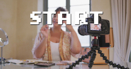 Image of start text over caucasian woman making vlog using camera. Global social media and digital interface concept digitally generated image.の写真素材