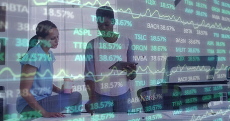 Image of financial data and graphs over diverse female coworkers in office. Business, finance, economy, cooperation and communication concept digitally generated image.の写真素材