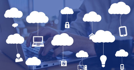 Image of clouds with icons over hands using laptop. Global business and digital interface concept...