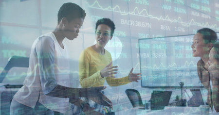 Image of financial data and graphs over diverse female coworkers in office. business, finance, economy, cooperation and communication concept digitally generated image.の写真素材